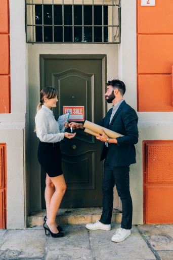 Agent handing keys to a homeowner at the front door