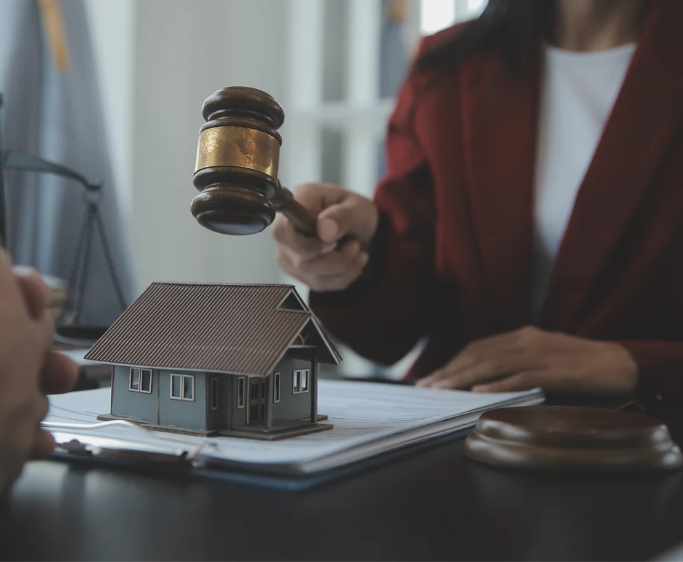 Auctioneer's gavel beside a model house